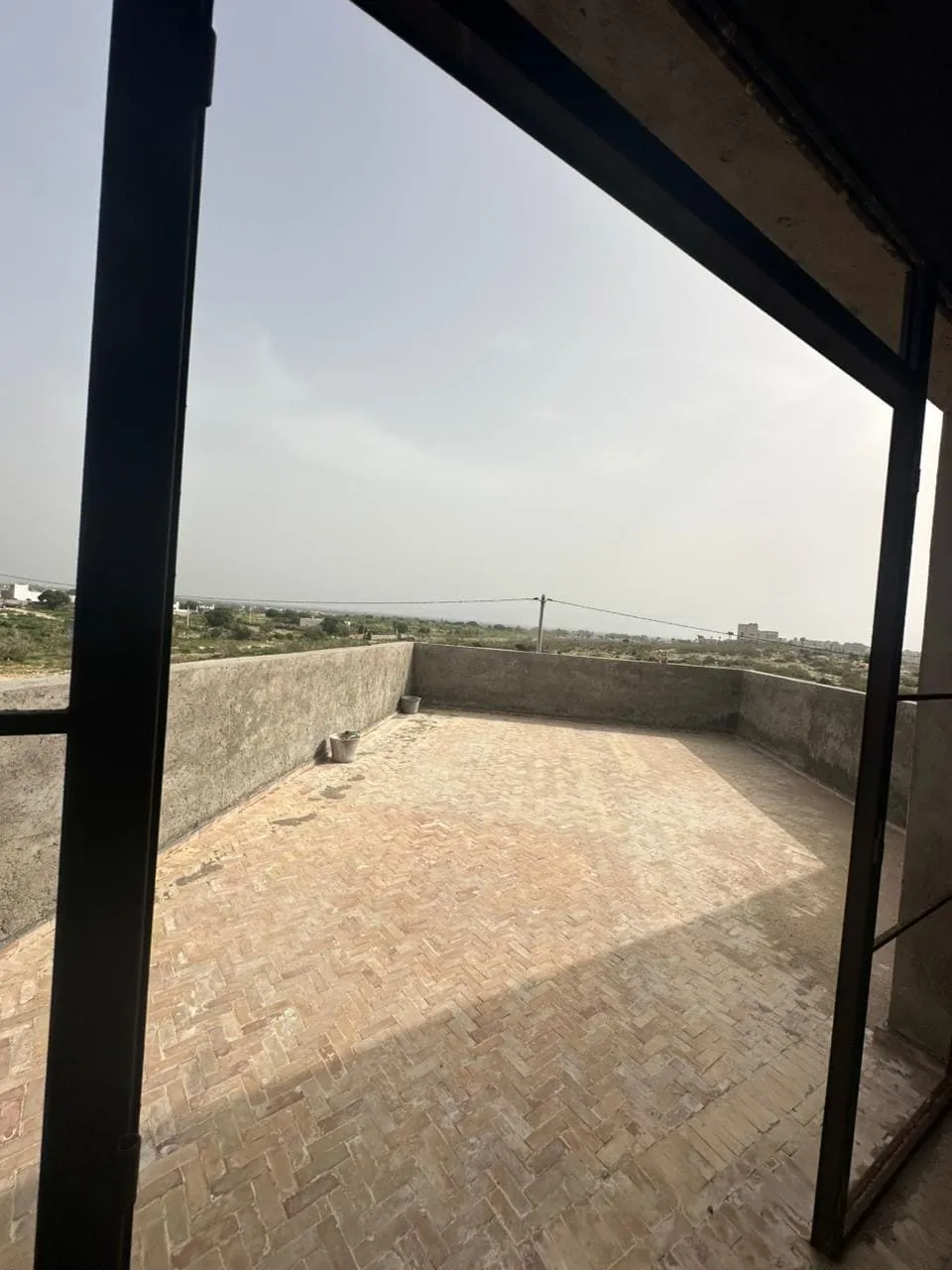 Open living area overlooking pool in contemporary Ghazoua villa