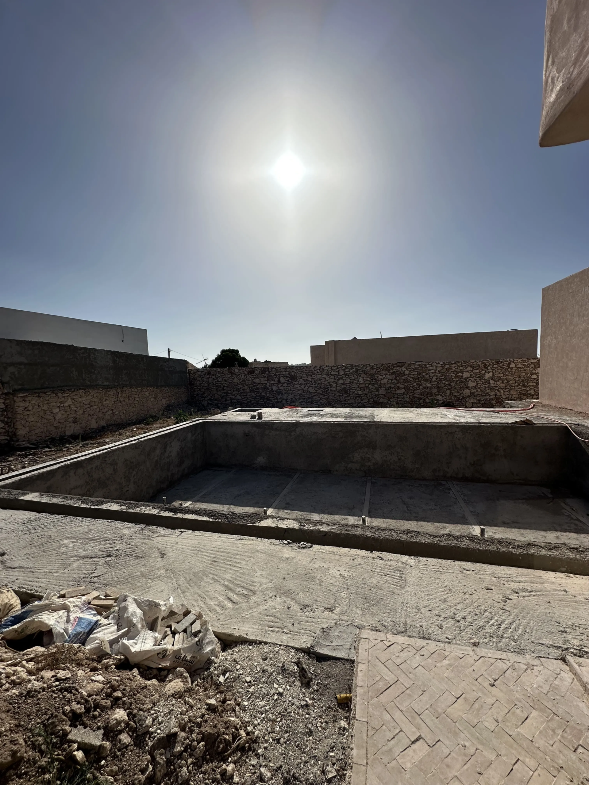 Bright pool area of a modern villa under finishing in Ghazoua