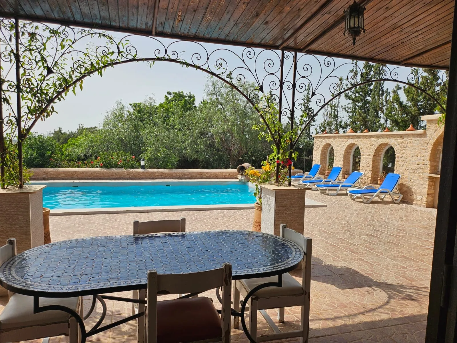 Outdoor dining area beside the garden and swimming pool
